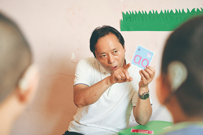 赵小平在给听障儿童做发音练习